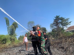 Sinergi : TNI, Polri Dibantu Warga Padamkan Kebakaran Lahan Kosong di Ngoro