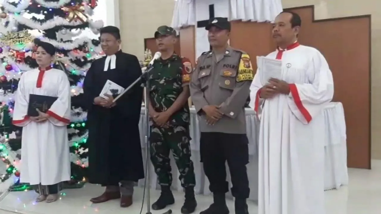 Sinergitas Babinsa dan Bhabinkamtibmas Laksanakan Pengamanan Misa Natal