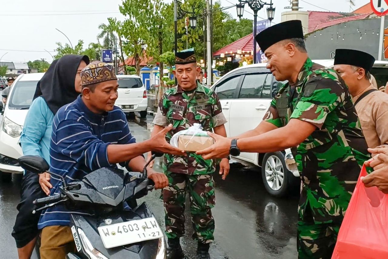 Caption : Dandim 0817/Gresik Letkol Inf Ahmad Saleh Rahanar S.Sos. Saat Membagikan Takjil Pada Pengguna Jalan di Kwasan Haritage Bandar Grissee Gresik