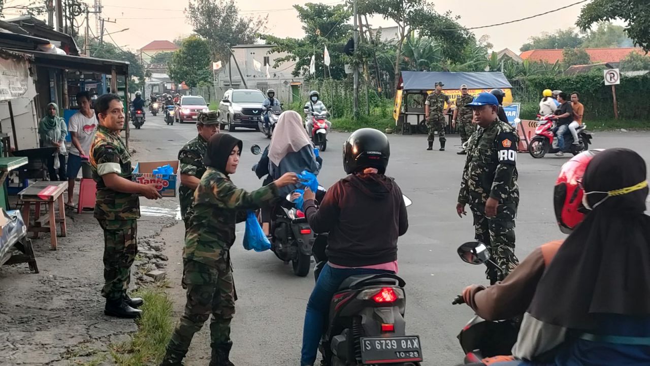 Caption : Anggota PPM Yudha Putra Kiban-08 Macan Lakarsantri, Saat Membagikan Paket Takjil Gratis ke Pengguna Jalan Didepan Makoramil 0832-08/Surabaya