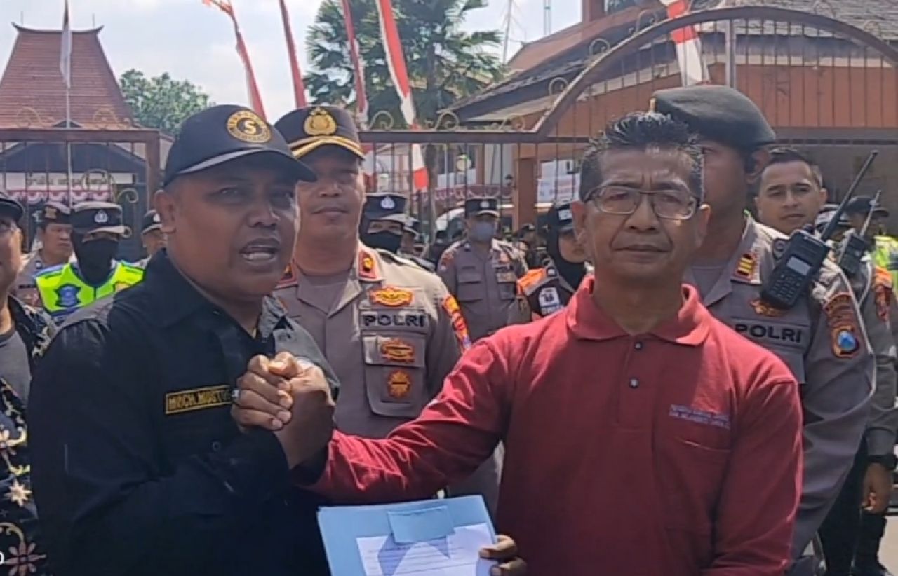 Tuntutan aksi : Korlap aksi unjuk rasa 'Penjarakan Rocky Gerung' Musthofa Mochammad memberikan surat tuntutan aksi pada Pemkab.Mojokerto yang diwakili oleh Kesbangpollinmas Kab.Mojokerto