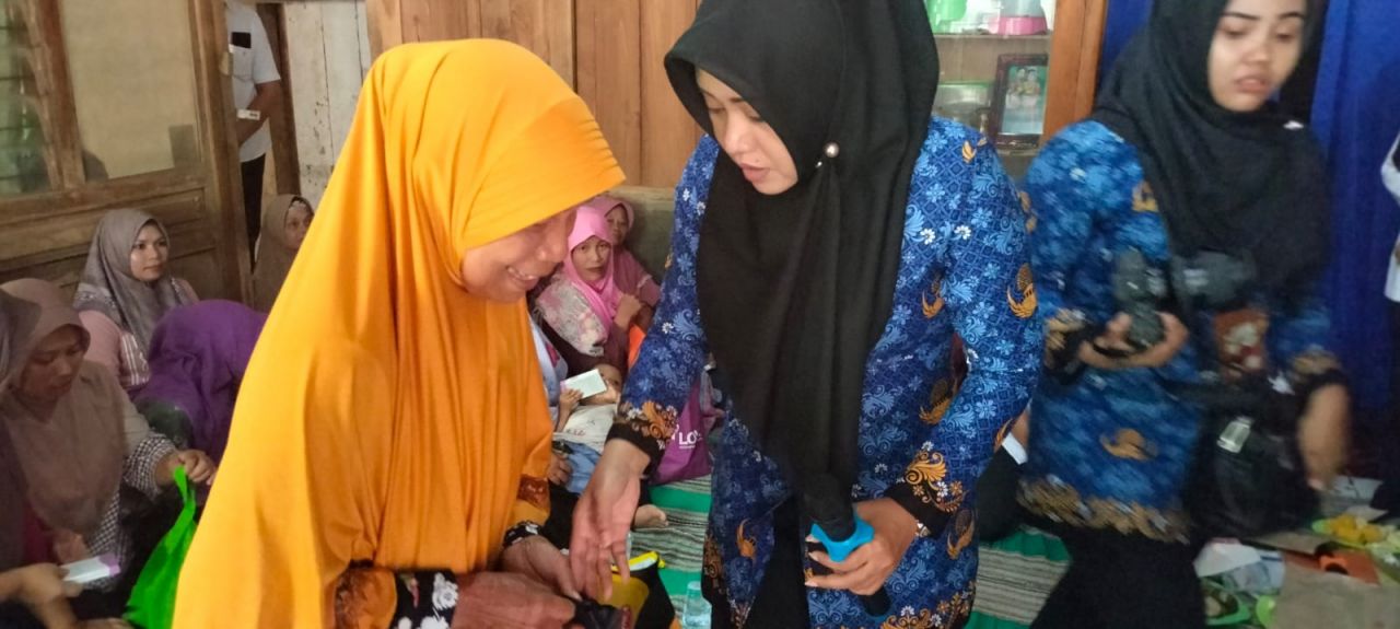 Bantu : Bupati Mojokerto dr.Ikhfina Fahmawati saat memberikan cindera mata kepada warga yang hadir dalam program Bulik Soima