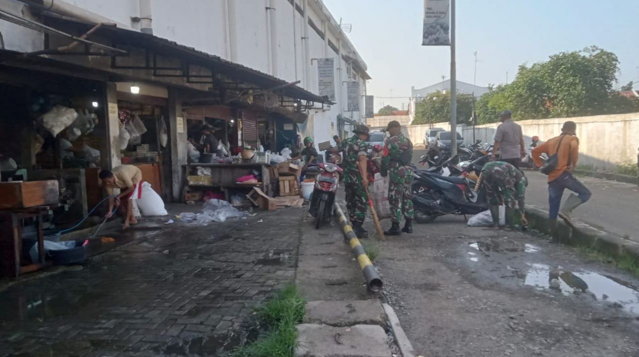 Bersih : Anggota Koramil 1908/PWK Pelda Dadan dibantu warga dan tokoh masyarakat laksanakan giat pembersihan sampah disekitar pasar simpang