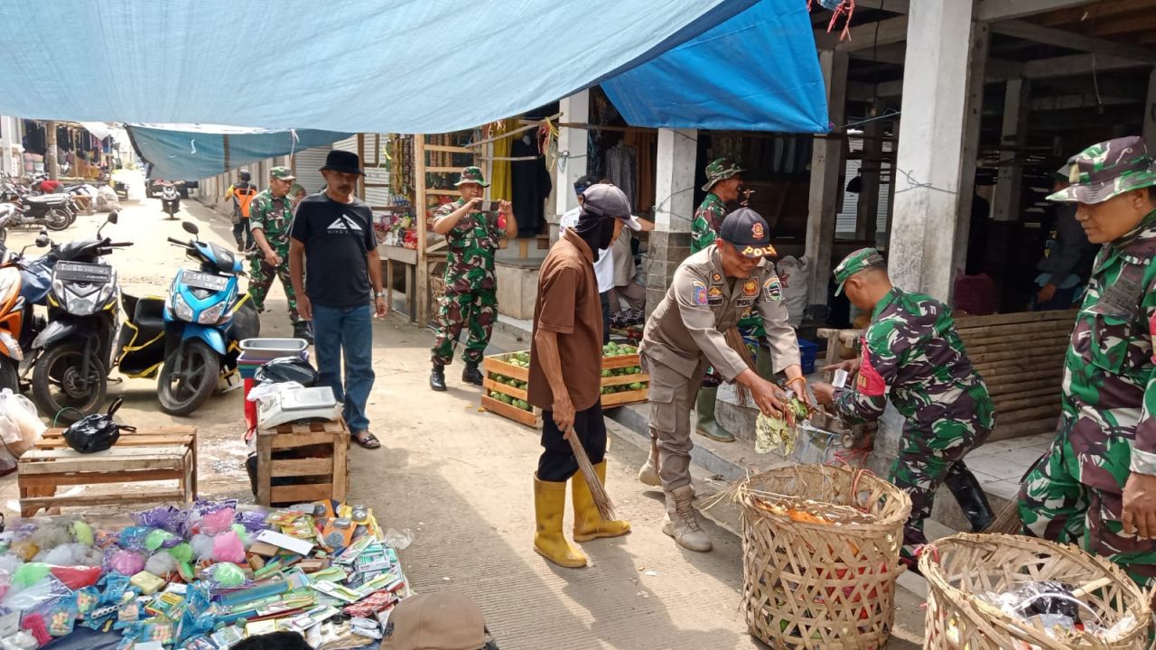 Bersihkan sampah : Serma Oyen dibantu warga dan pedagang pasar Wanayasa membesihkan sampah dan rumput