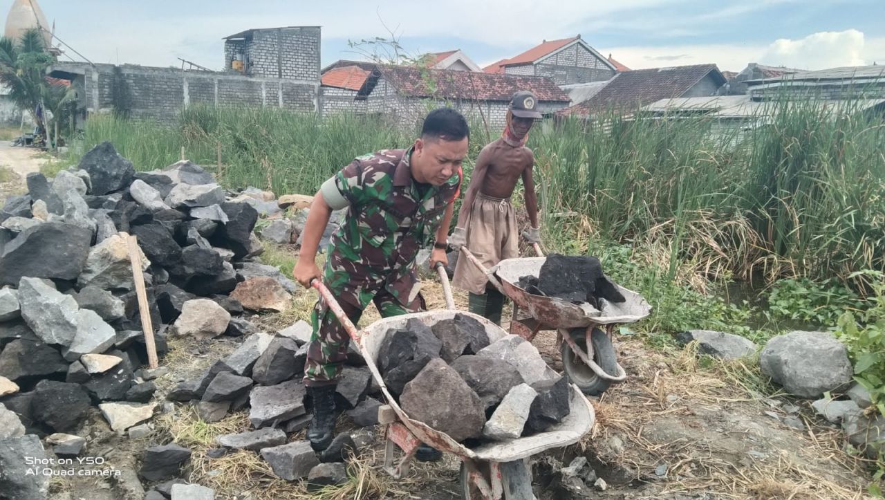 Bantu : Serda Suwarto Babinsa Koramil 0817/11 Duduksampeyan membantu warga dalam pembangunan plengsengan diwilayah binaannya