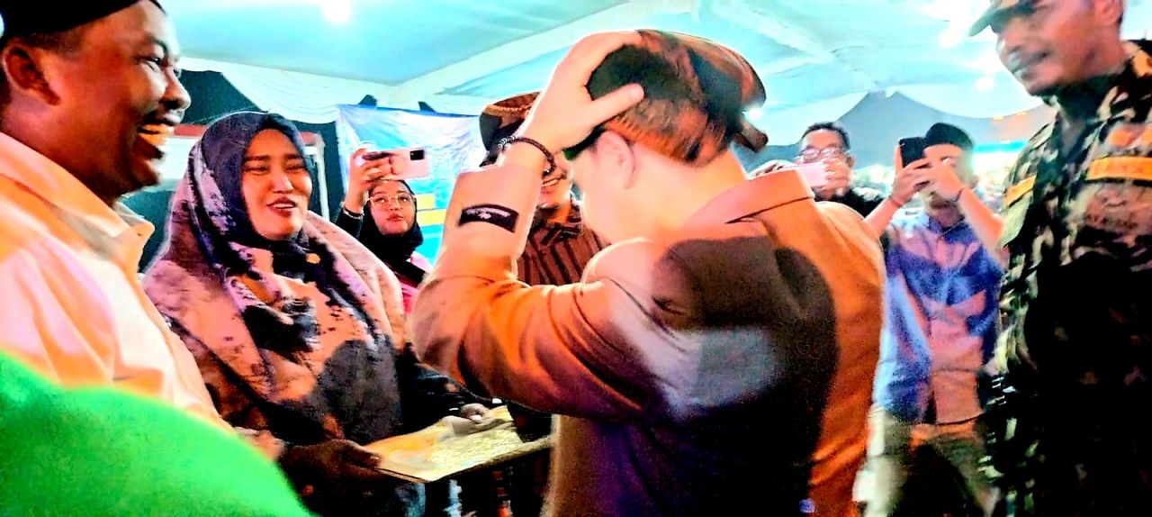 Sambut : Kehadiran Wakil Bupati Mojokerto pada acara sedekah desa disambut Kepala Desa Brangkal dengan memberikan Blangkon (penutup atau ikat kepala lelaki dalam tradisi busana adat Jawa) (Dok//Riex_beritaformat.com)