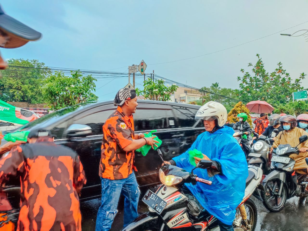 Berbagi : M. Agus Fauzan saat membagikan takjil untuk pengguna jalan yang sedang melintas di Jl. Raya Pahlawan (depan kantor ormas Pemuda Pancasila) doc.PP/RX_beritaformat.com