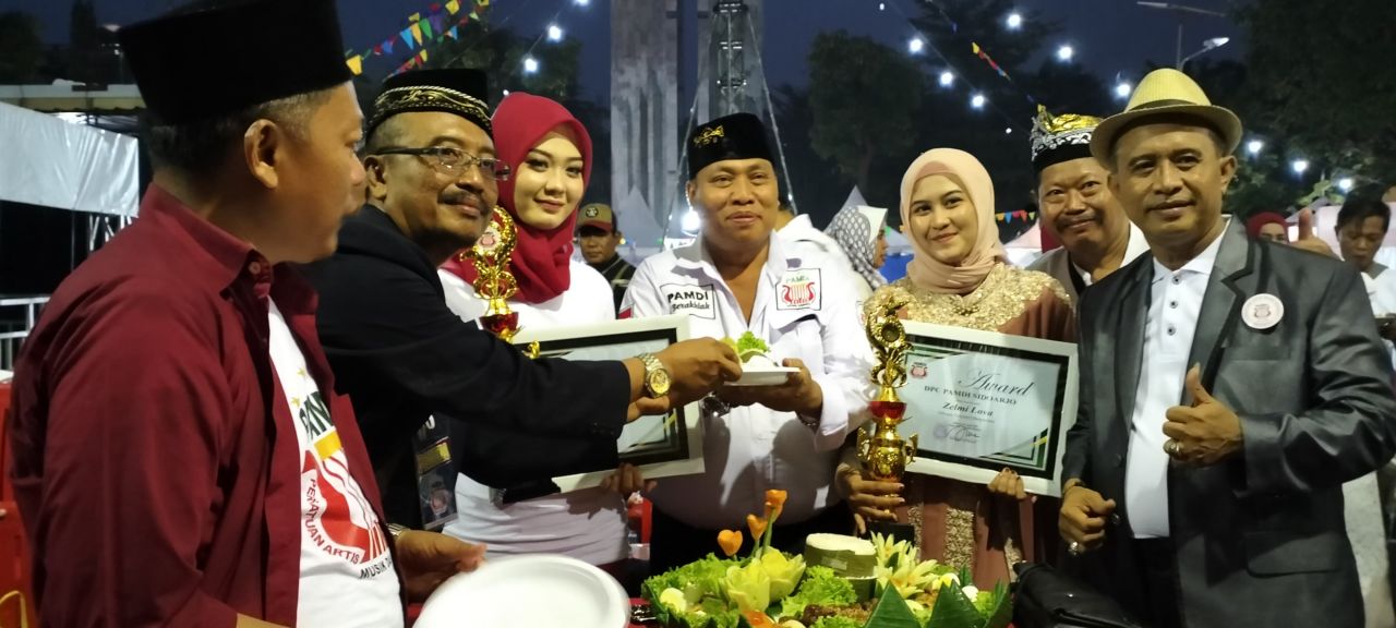 Syukur : Ketua DPC PAMDI Sidoarjo Den Bagus Adjie Mardjono menerima potongan tumpeng sebagai ucapan selamat (doc.Zies_beritaformat.com)