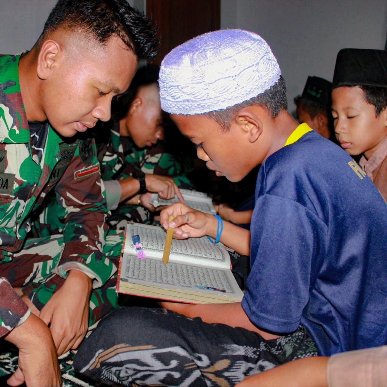 Anggota Satgam TMMD Kodim 0619/PWK memberikan pendampingan belajar ngaji dan baca Al Qur'an bagi anak-anak Desa Gurudug (foto : pendim0619-pwk/v-to_beritaformat.com)