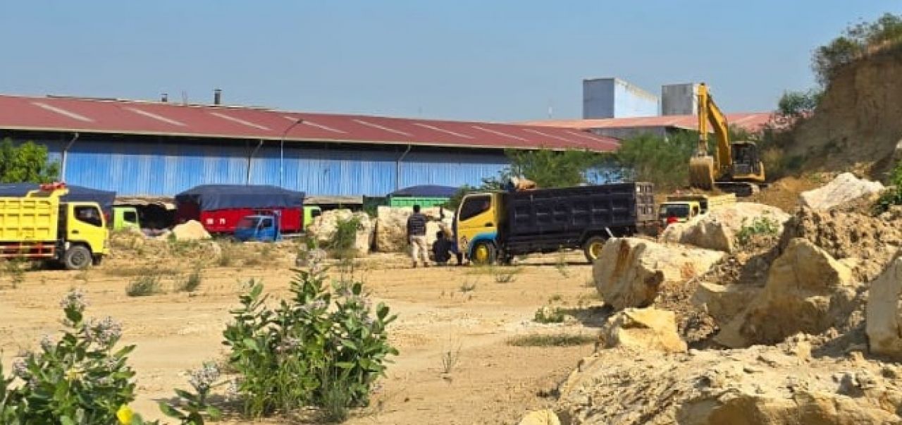 Alat berat jenis excavator terlihat sedang melakukan pengisian material ke bak dumptruk yang sedang antri mengular didalam pabrik PT Aplus Pasific (foto : tim/redaksi_beritaformat.com)