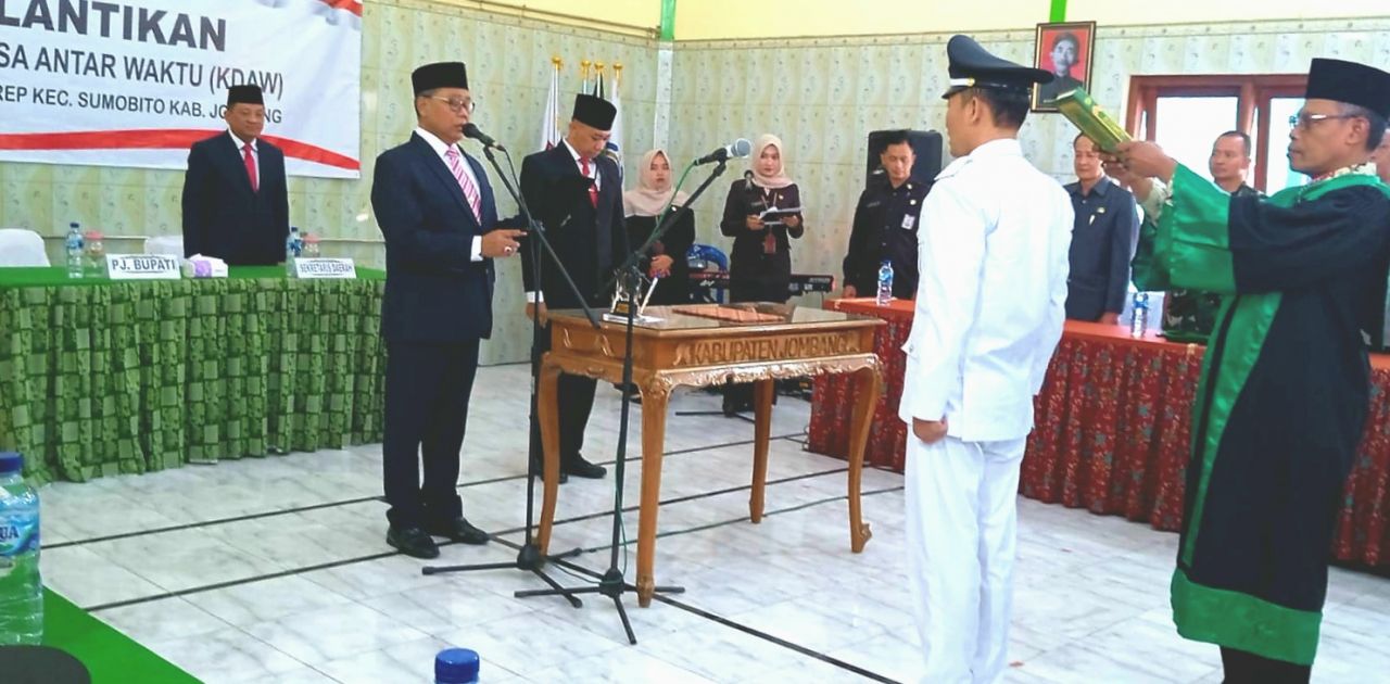 Pj Bupati Jombang Sugiat, S.Sos., membacakan sumpah janji Syahbiyan Alam Saputro, S.H., dibawah sumpah Al Qur'an yang dibawah rohaniawan sebagai Kades Plosokerep yang baru (foto : lek dar_beritaformat.com)