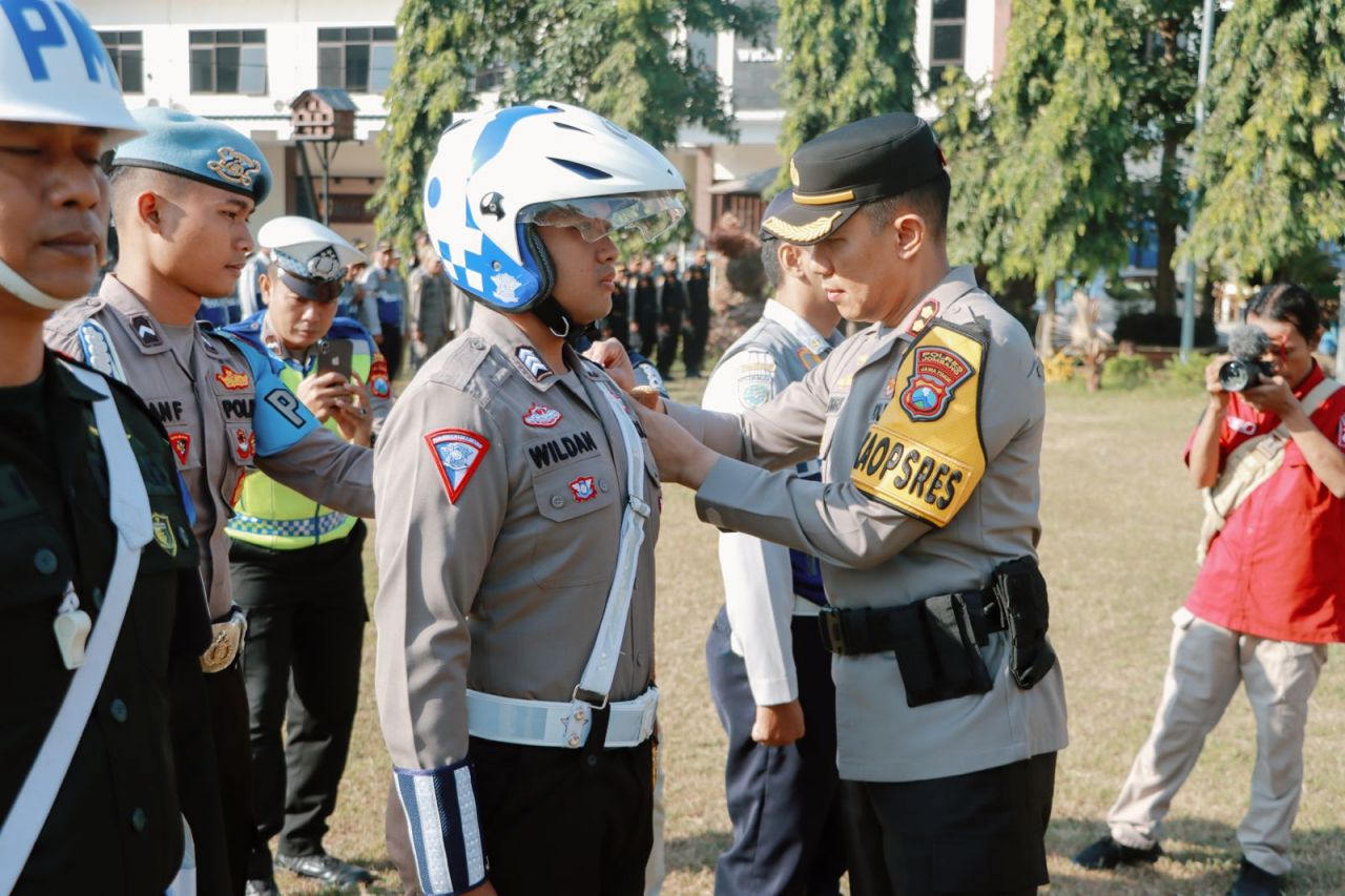 Kapolres Jombang AKBP Eko Bagus Riyadi menyematkan pita di lengan kiri (red_tanda operasi khusus kewilayahan) kepada salah satu anggota Satlantas Polres Jombang (foto : penmasresjbg/darmanto_beritaformat.com)