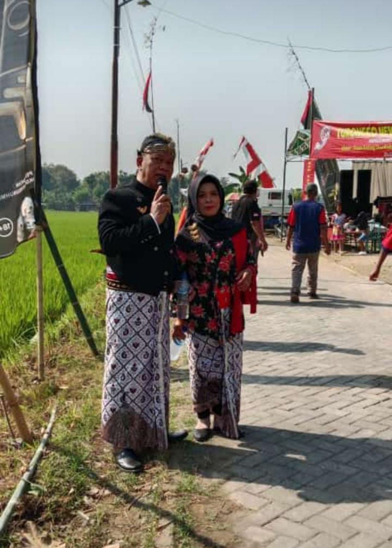 Kades Bedahlawak H.Masrum bersama istri mengenakan pakaian adat jawa saat memberikan sambutan pada acara pawai budaya memperingati 1 Muhatram dan sedekah bumi Desa Bedahlawak (foto: darmanto_beritformat.com)