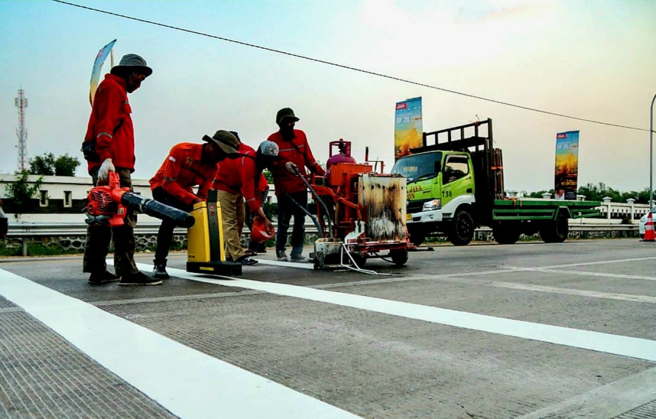 Petugas dari BPTD Jawa Timur sedang malakukan pemasangan garis kejut antisipasi kecelakaan di jalan raya (foto : darmanto_beritaformat.com)
