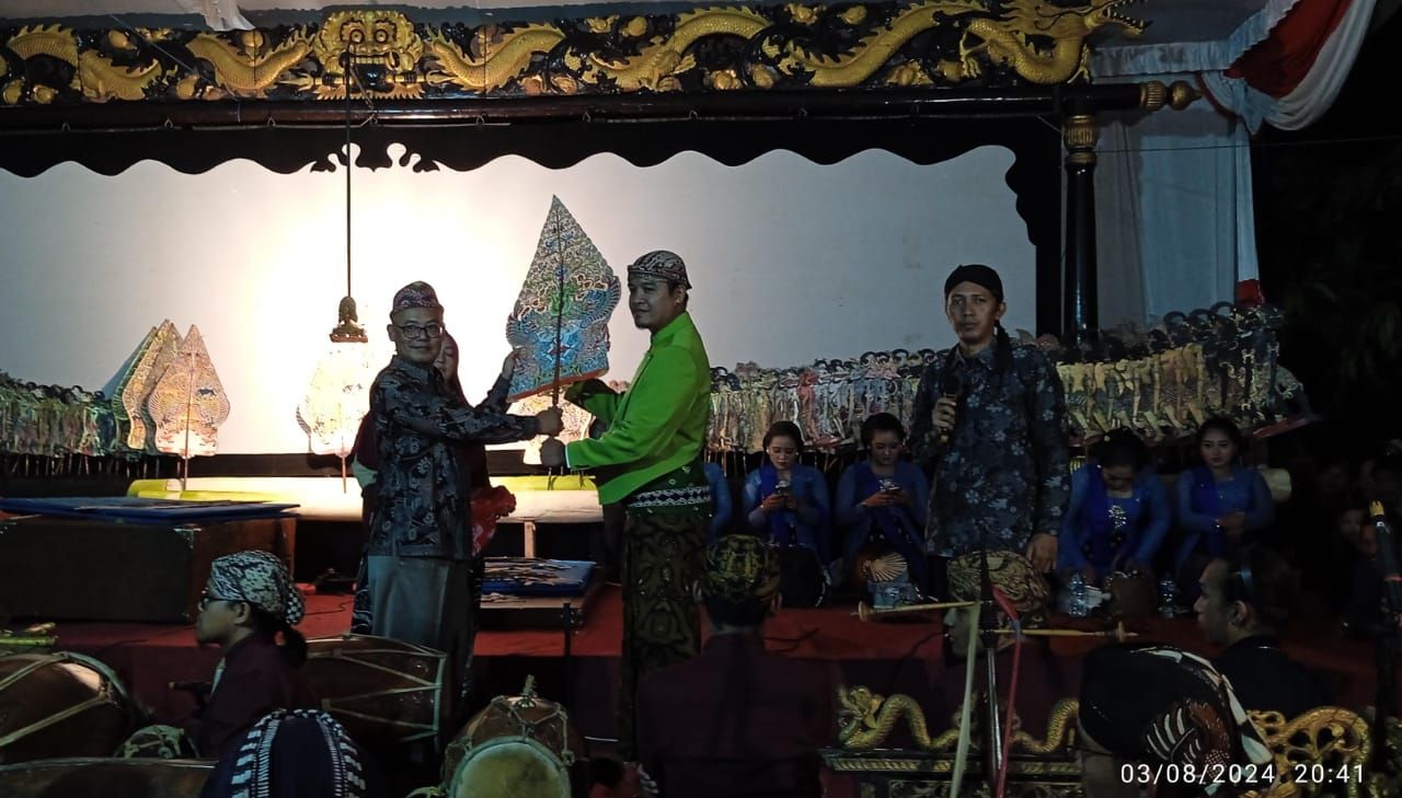 Kades Karanglo Habib Ghofir,S.Ip., memberikan gunungan wayang kepada Ki Dalang Sekti Aji yang akan menampilkan pagelaran wayang kulit memperingati HUT ke 116 dan sedekah bumi Desa Karanglo (foto : darmanto_beritaformat.com)