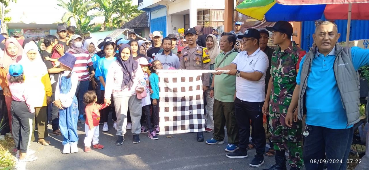Kades Pulo Gedang Eko Ariyanto mendampingi Anas Burhani (baju putih) memberangkatkan peserta jalan sehat dari depan Balai Desa Pulo Gedang (foto : darmanto_beritaformat.com)