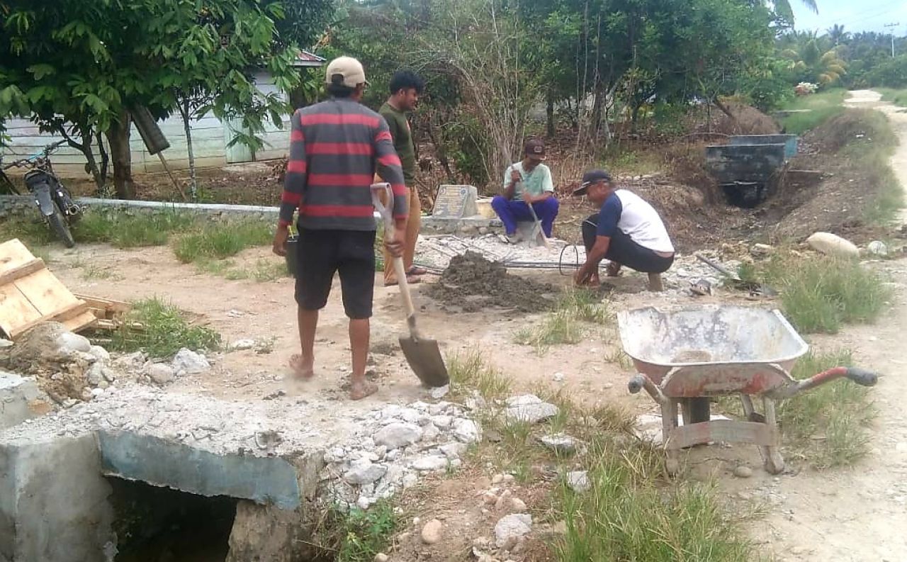 Perangkat dan Sekdes Ogorandu bergotong royong perlebar plat deker untuk memudahkan mobilisasi hasil panen pertanian warga (foto : asri_beritaformat.com)