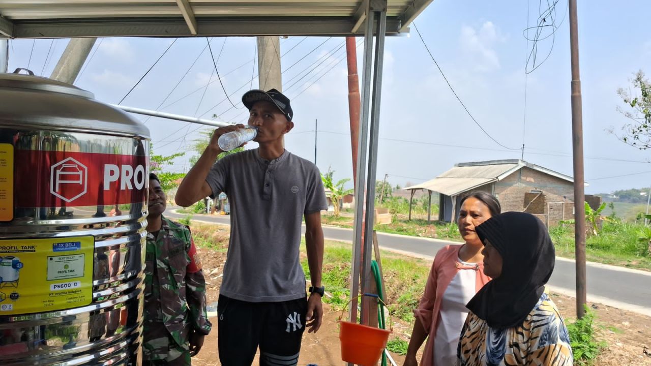 Salah satu warga mencoba langsung meminum sumur bor siap minum yang dibangun oleh anggota TMMD ke-122 Kodim 0809/Kediri (foto: pendim0809-kediri/krisna_beritaformat.com)