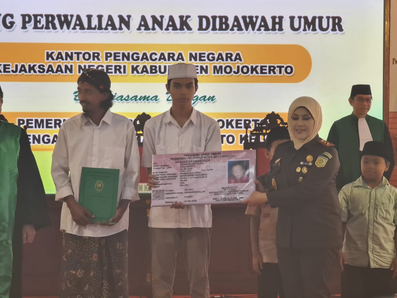 Kepala Kejaksaan Negri Kabupaten Mojokerto secara simbolis menyerahkan Kartu Tanda Penduduk (KTP) usai sidanb perwalian (foto : humaskabmjk/erick_beritaformat.com)