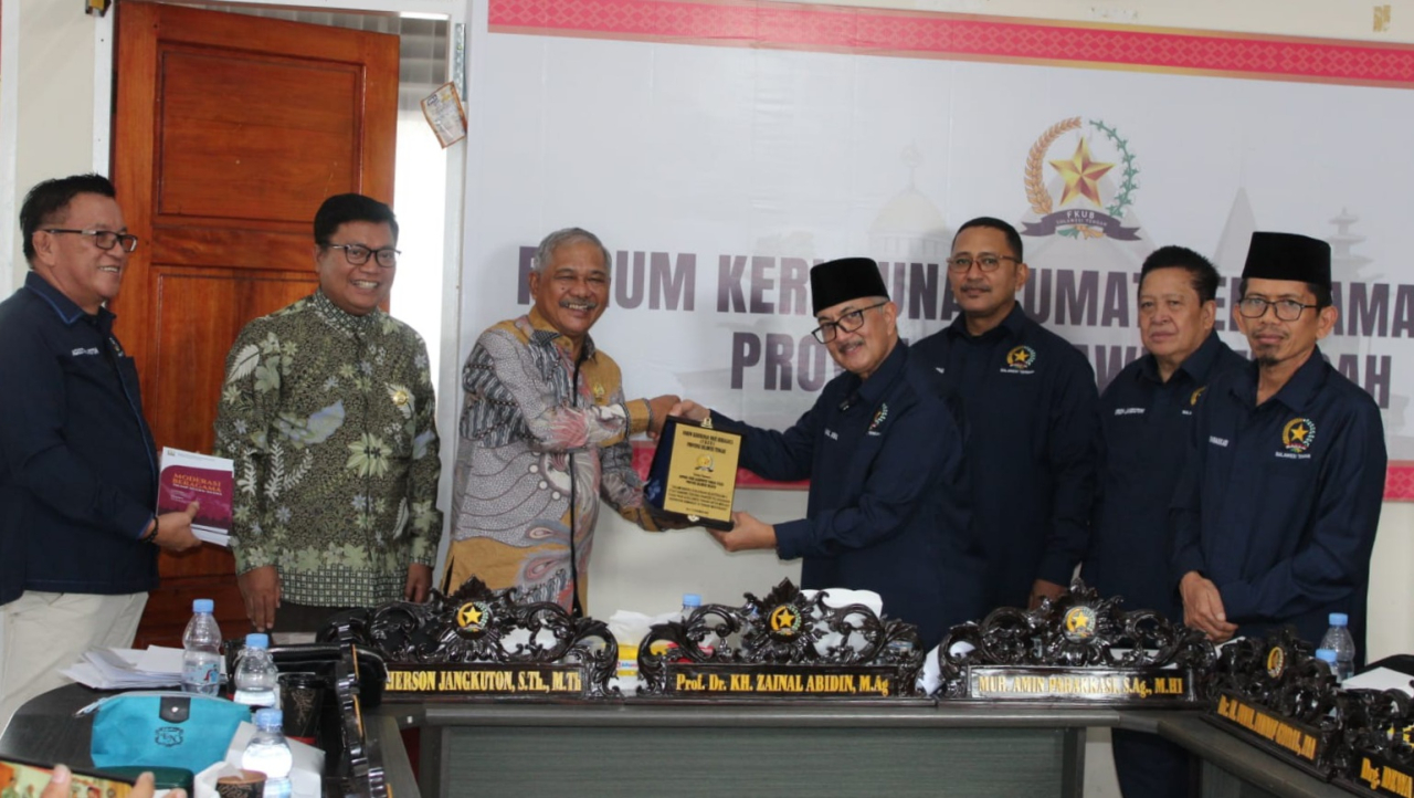 Ketua FKUB Sulteng Prof. KH Zainal Abidin M.Ag., saat memberikan cinderamata kepada Ketua FKUB Toraja Utara Pendeta Musa Salusu (foto : fkubtorut/asri_beritaformat.com)