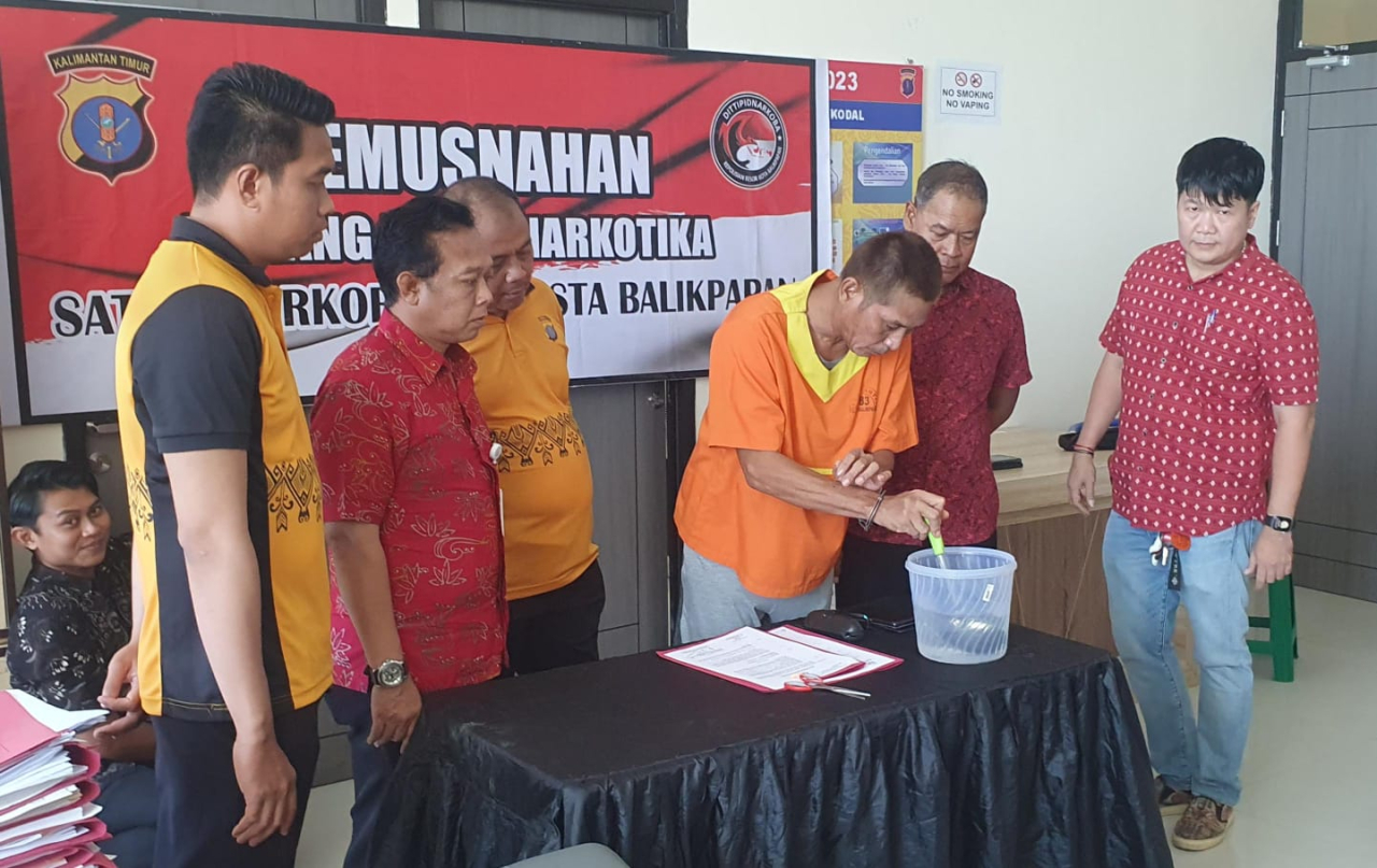 Tersangka HS memusnahkan BB sabu dengan cara mengaduk dengan air panas didalam toples yang sudah disiapkan petugas (foto : humasrestabalikpapan/salahudin_beritaformat.com)