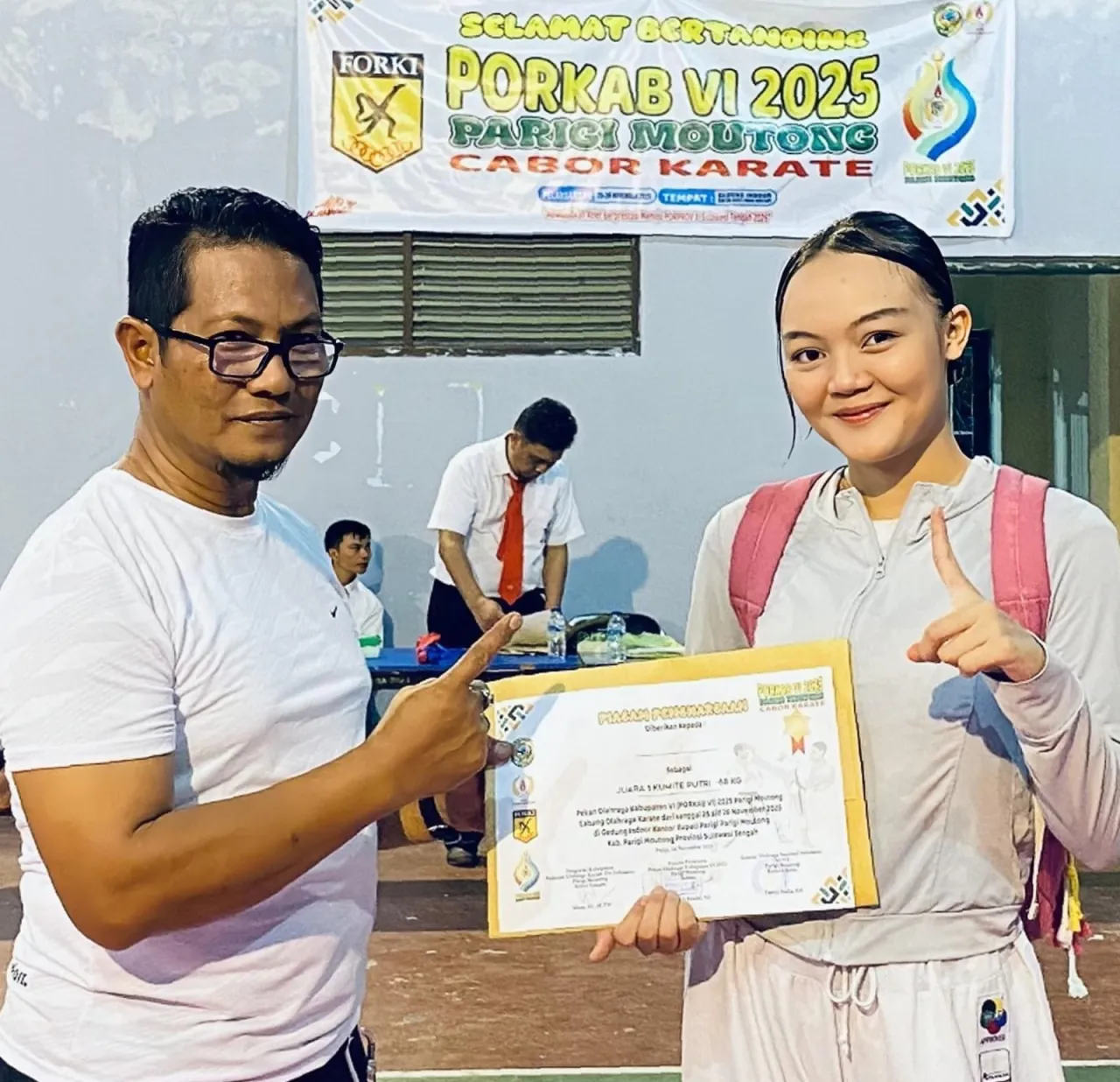 Sesil saat menerima tropi juara karate kelas 68 kg (foto : enos_beritaformat)