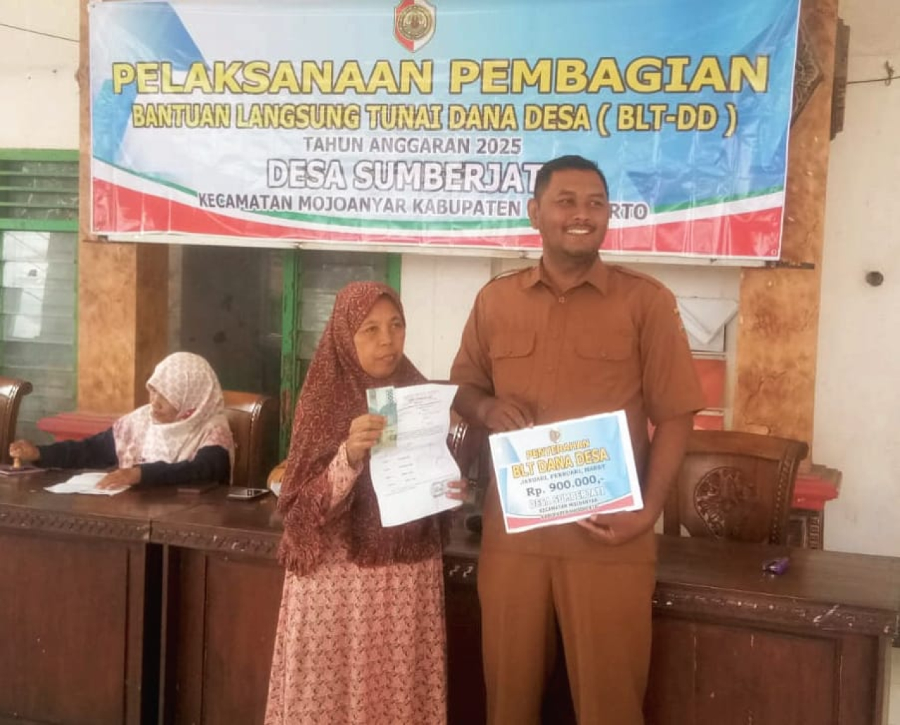 Kepala Desa Sumberjati, Ari Kusuma secara simbolis menyerahkan BLT kepada perwakilan warga (foto : hartono_beritaformat.com)