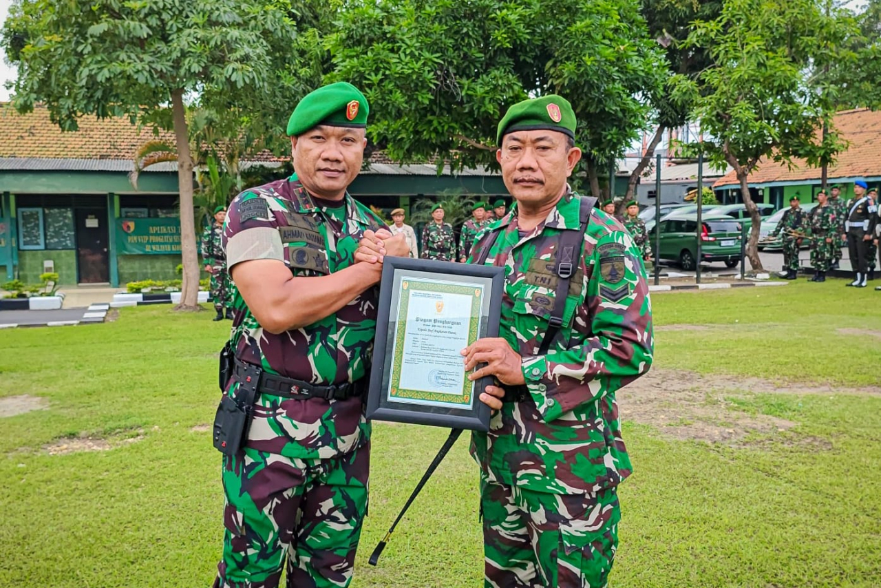 Komandan Kodim 0817/Gresik Letkol Inf Ahmad Saleh Rahanar, S.Sos., serahkan penghargaan dari Kasad kepada Serka Muhadi (foto : pendim0817/hartono_beritaformat.com)