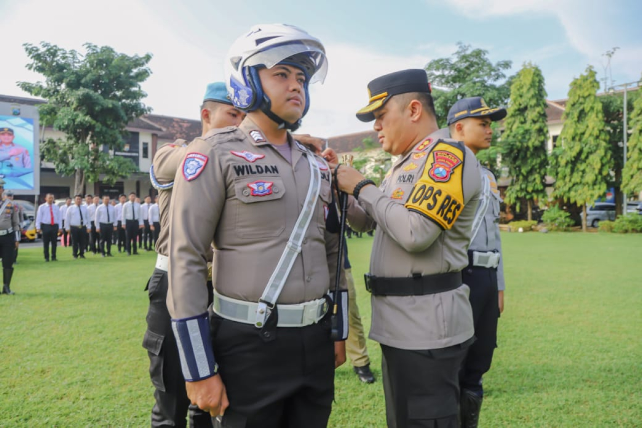 Kapolres Jombang AKBP Ardi Kurniawan, S.H., S.I.K., CPHR., sematkan pita pada anggota Satlantas Polres Jombang (foto : sulistyowati_beritaformat.com)