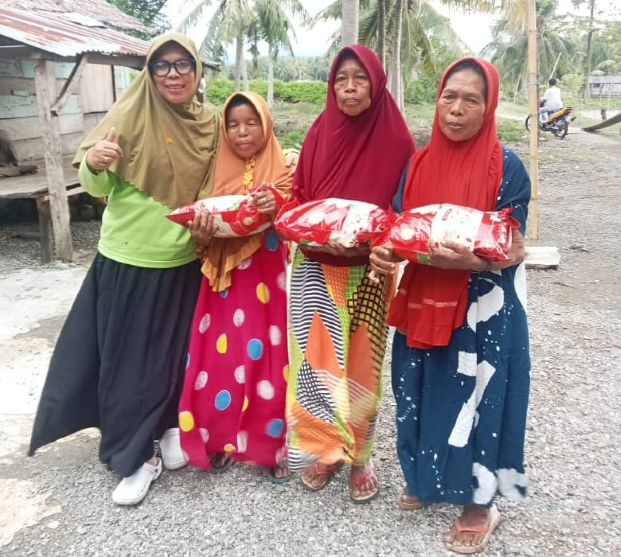 Pj Kades Toribulu Selatan, Na'ima saat membagikan bantuan beras kepada warga masyarakat (foto : asri_beritaformat.com)