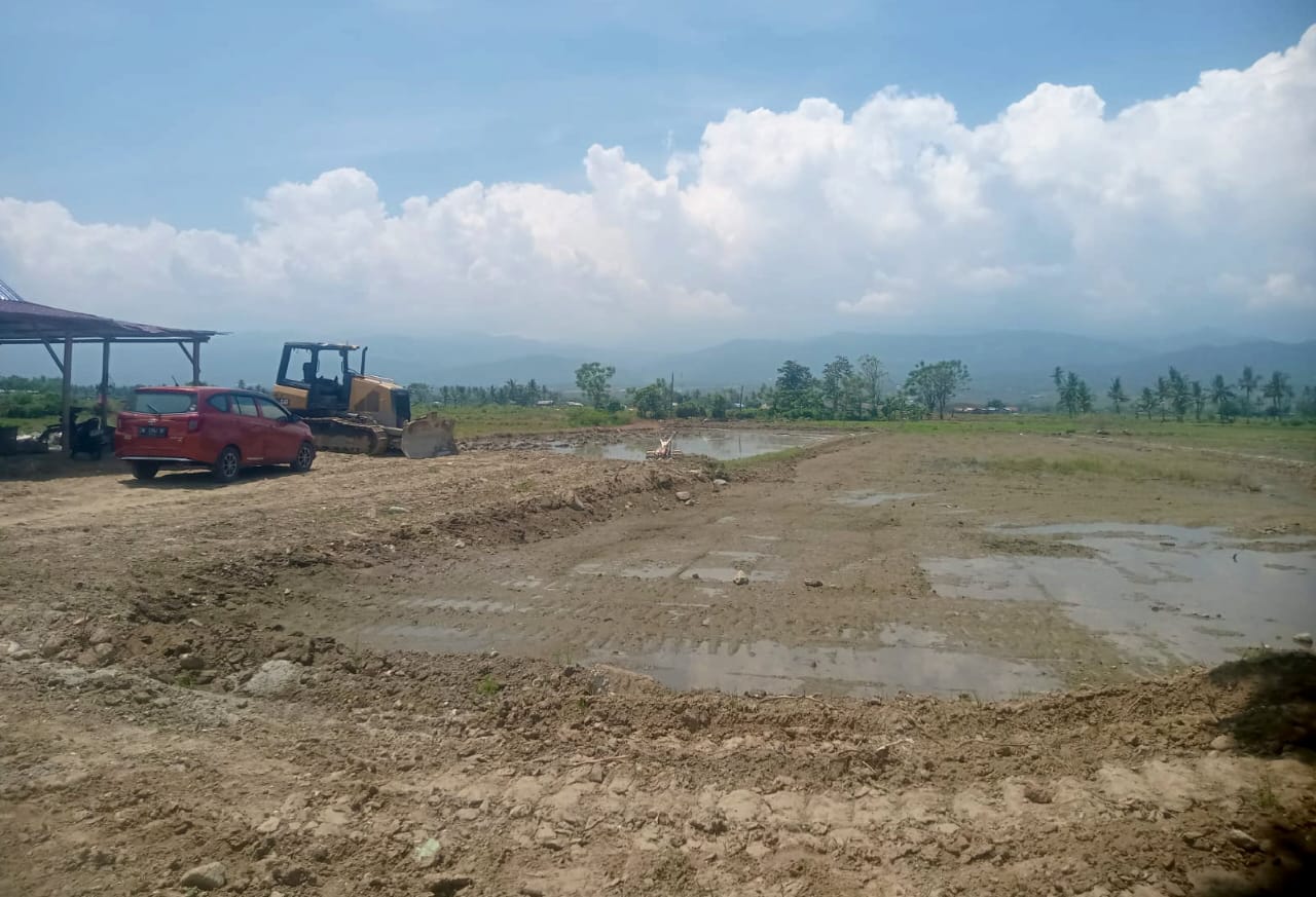 Lokasi perataan lahan pasca gempa dan likuifaksi Desa Karawana, Kecamatan Dolo dengan mengunakan alat berat (foto : agus/asri_beritaformat.com)
