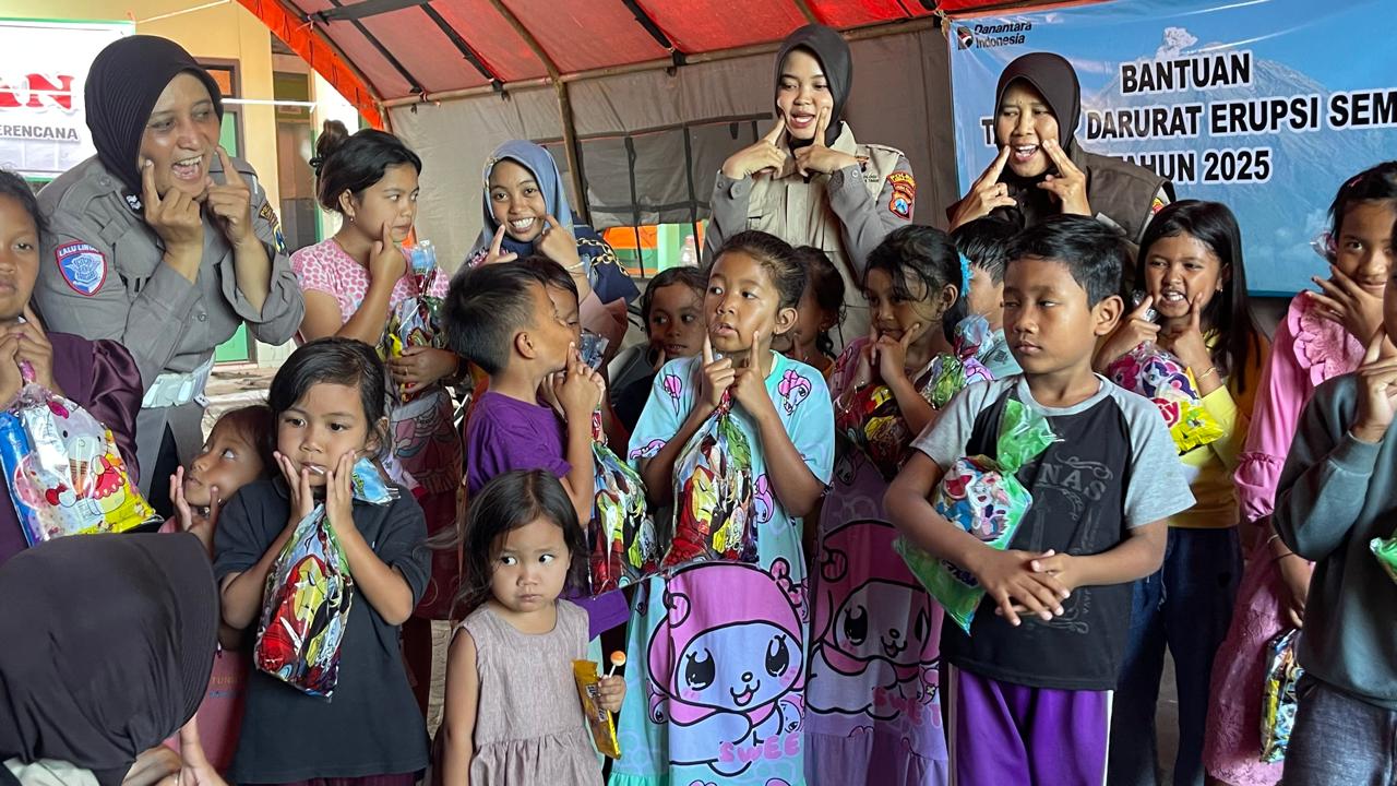 Ketua Tim Psikologis Polres Lumajang bersama anggota bagian SDM Polres Lumajang saat mengajak anak-anak pengungsi erupsi semeru melakukan permainan untuk pemulihan trauma (foto : bagus_beritaformat)