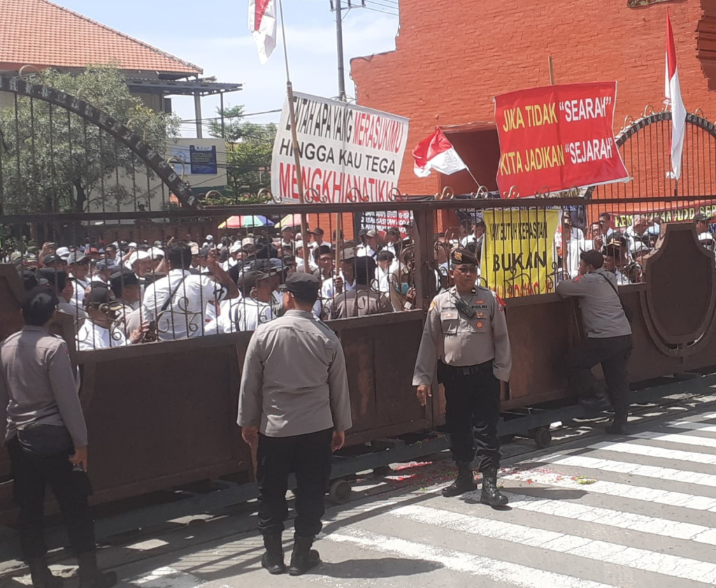 Massa aksi dari PKDI se-Kabupaten Mojokerto melakukan orasi dan menuntut untuk membatalkan Perbup terkait pemangkasan ADD tahun 2026 di depan kantor Bupati (foto : clara_beritaformat)