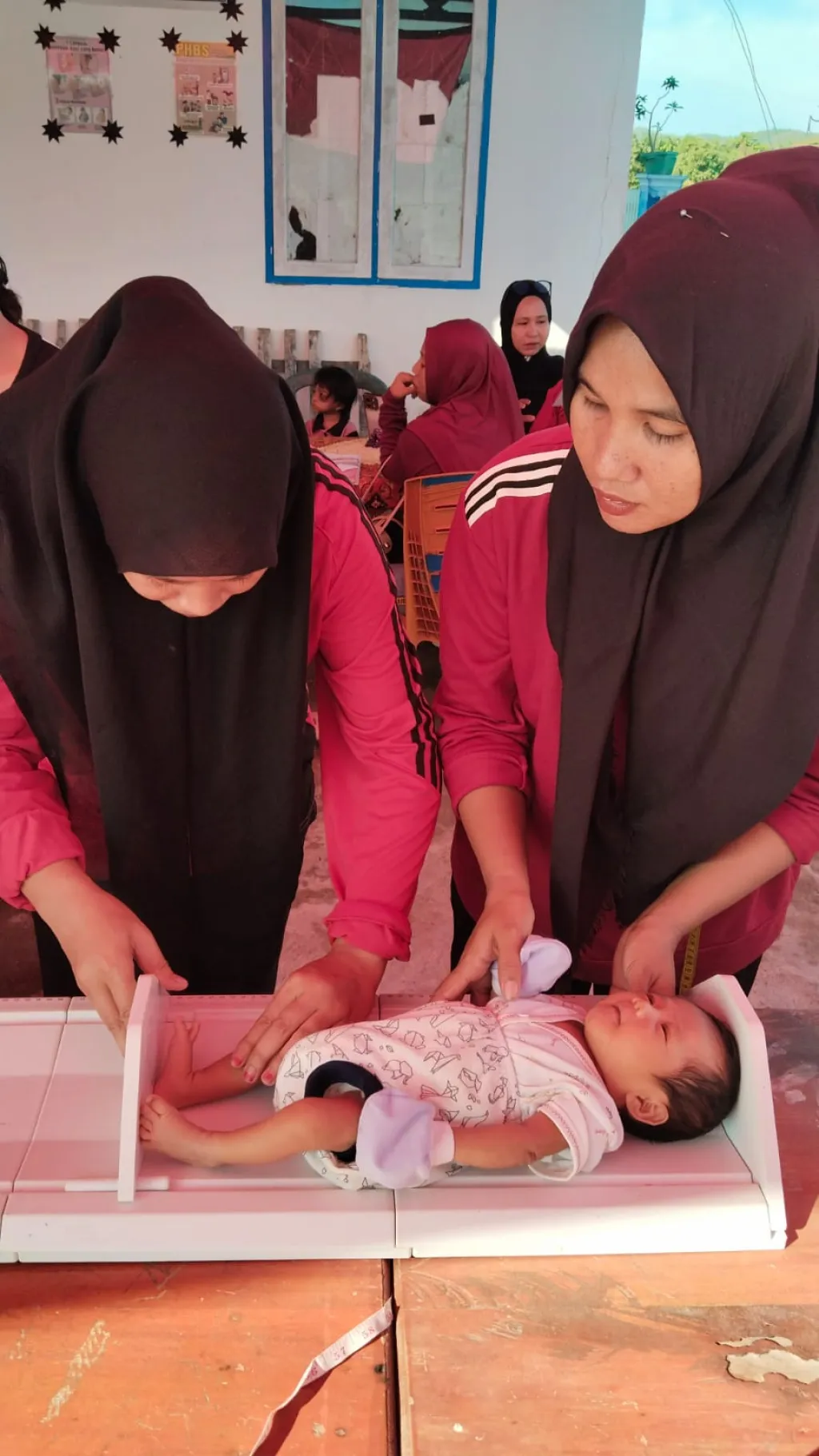 Penimbangan balita oleh kader kesehatan puskesmas lambunu 1 (foto : asri_beritaformat)