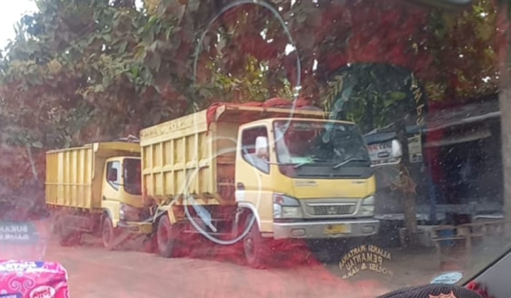 Tampak dua dumptruk diduga bermuatan tanah paras yang baru saja keluar dari lokasi tambang milik IKS (foto : loecash_beritaformat)
