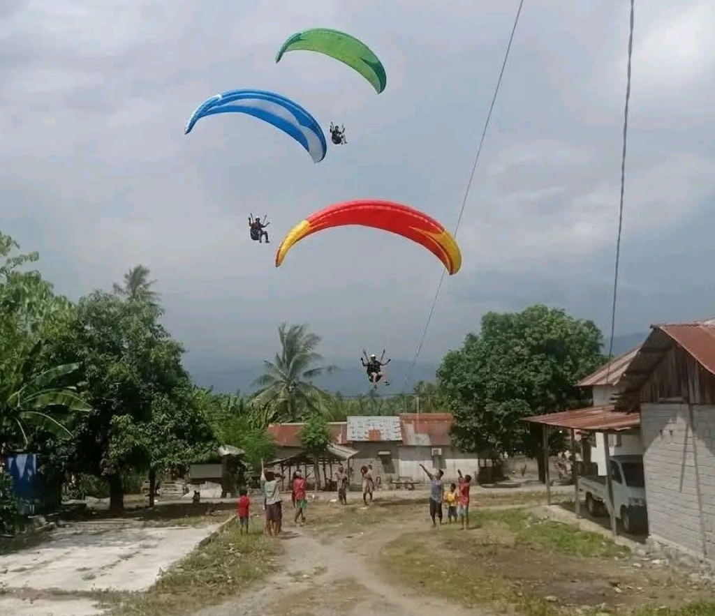 Sejumlah peserta event paralayang kelas dunia yang terbang rendah di permukiman warga Sigi (foto : anjasman_beritaformat)