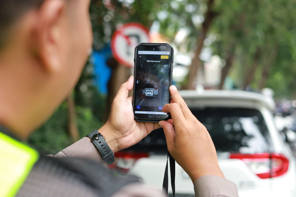 Petugas Satlantas Polres Gresik menscan data kendaraan pada sistem aplikasi e-tilang (foto : anisah_beritaformat)