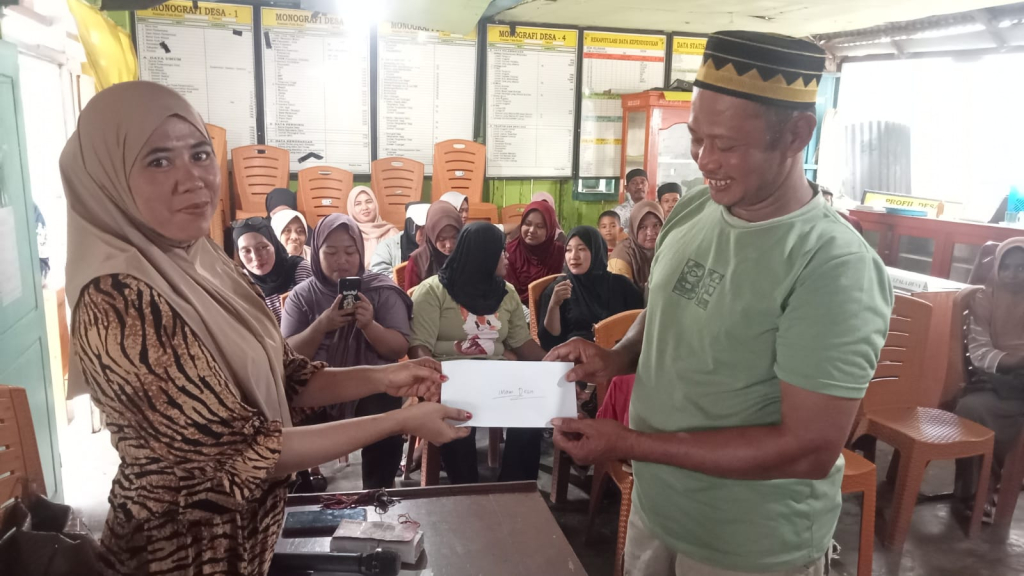 Kepala Desa Bolano Barat memberikan tunjangan kepada perwakilan kader (foto : asri_beritaformat)