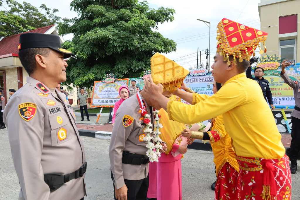 Kapolda bersama istri menerima pengalungan bunga serta pemasangan siga dan sampolu (foto : asri_beritaformat)