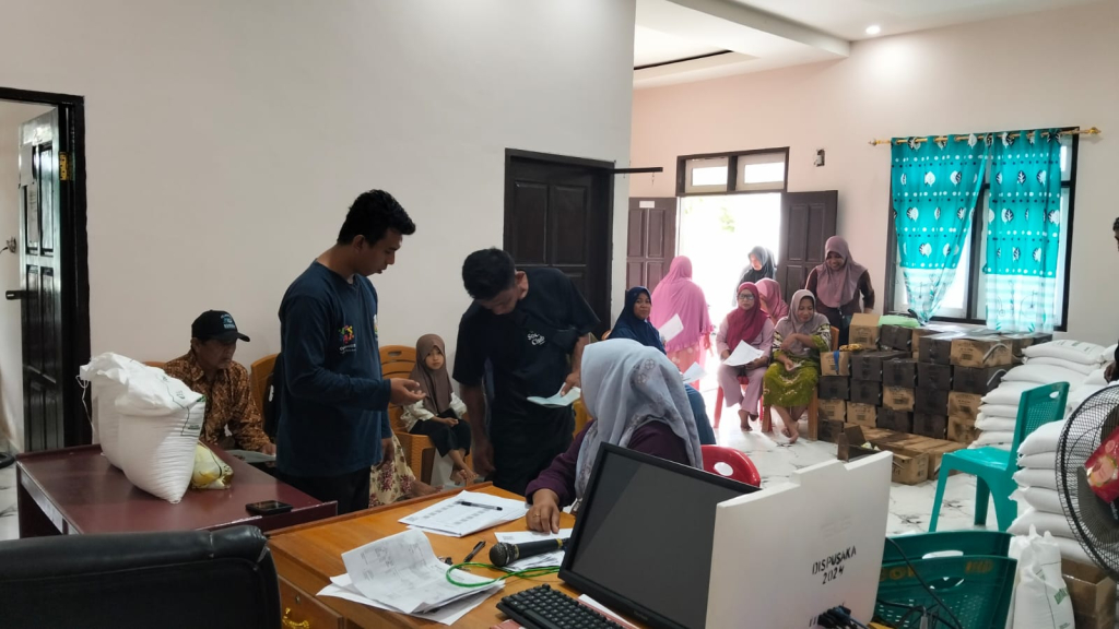 Pemdes Bolano Induk saat mendistribusikan bantuan beras dan minyak kepada sejumlah warga berpenghasilan rendah (foto : Asri_beritaformat)
